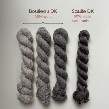 Four skeins of yarn in shades of gray and charcoal are arranged vertically on a light background, with text labels above reading Bouleau DK 100% wool and Saule DK 60% wool 40% mohair.